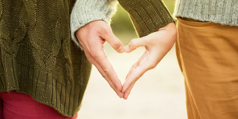 Heart-shaped hands signifying cohabiting partners with a cohabitation agreement
