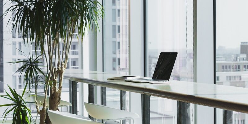 Laptop on a high table in a flexible working environment signifying hybrid working.