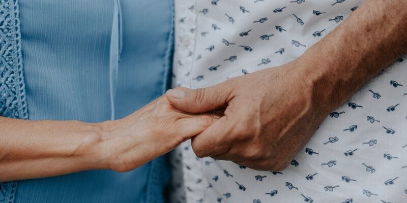 Couple holding hands signifying second marriage after bereavement.