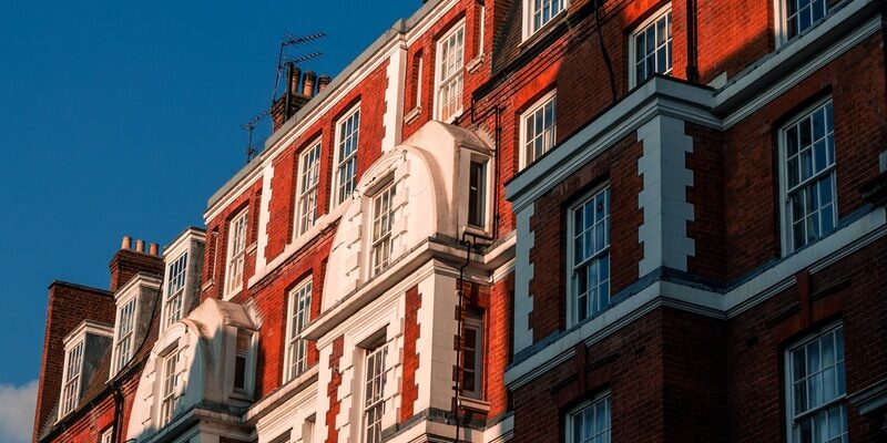 Redbrick mansion block against a blue sky signifying landlord and tenant issues and eviction notices.