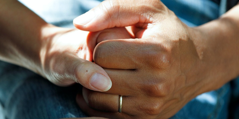Hands being held, signifying caring for a loved one and Kate Garraway's story.